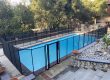 Baby Barrier removable pool safety fence with heavy duty gate installed around a residential swimming pool