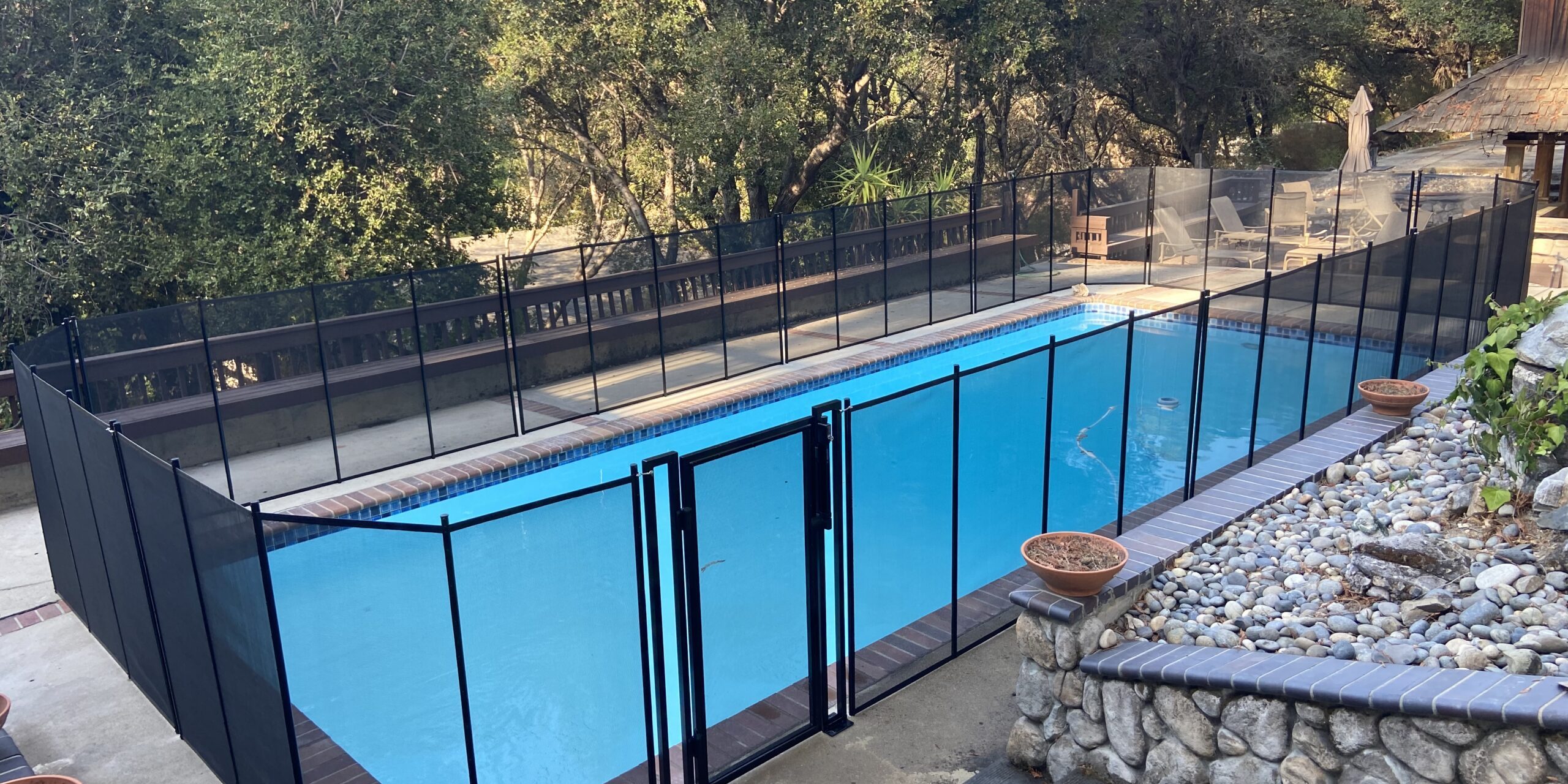Baby Barrier removable pool safety fence with heavy duty gate installed around a residential swimming pool