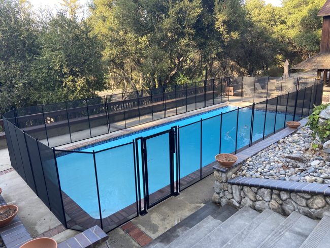 Baby Barrier removable pool safety fence with heavy duty gate installed around a residential swimming pool
